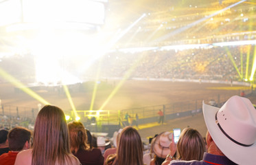 Concert stage with shining lights and crowd at a performance. Rock music event at a stadium with colorful spotlights and projectors.