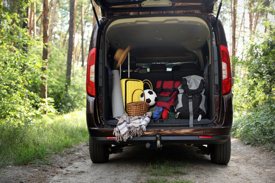 Van with camping equipment in trunk outdoors