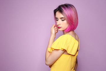 Young woman with trendy haircut against color background © New Africa
