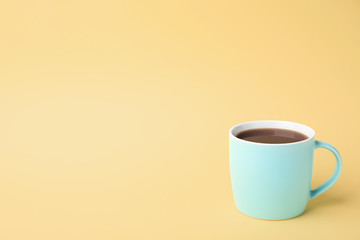 Blue ceramic cup with hot aromatic coffee on color background
