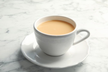 Obraz na płótnie Canvas Cup with black tea and milk on marble table