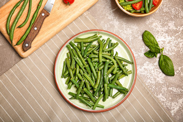 Plate with tasty green beans on table, top view