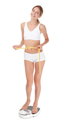 Fototapeta premium Happy slim woman with measuring tape and bathroom scales on white background. Weight loss diet results