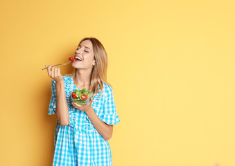 Happy slim woman with salad on color background. Weight loss diet