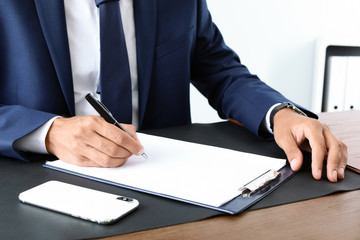 Male lawyer working with documents at table, closeup. Notary services