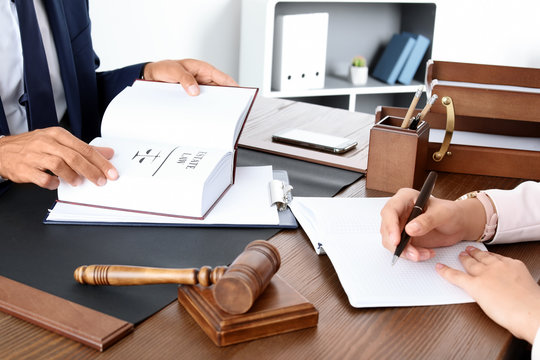 Male lawyer working with client at table in office