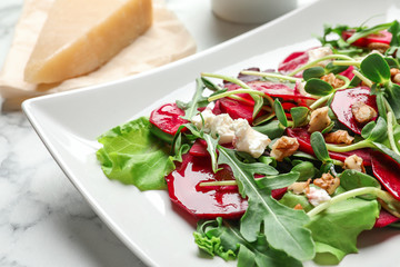 Plate with delicious beet salad on table, closeup
