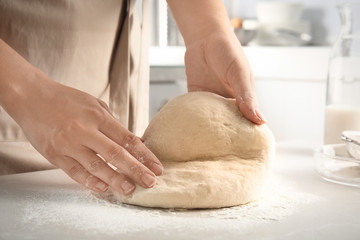 Woman kneading dough for pastry on table