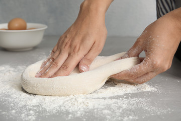 Woman kneading dough for pastry on table