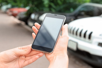 Woman holding modern smartphone outdoors. Mock up with space for text
