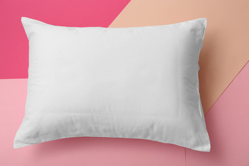 Soft bed pillow on color background, top view