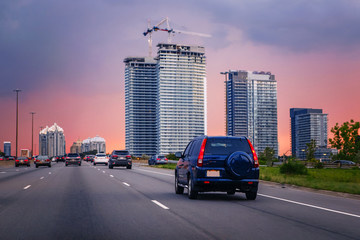 Night traffic. Cars on highway road at sunset evening in typical busy american city. Beautiful...