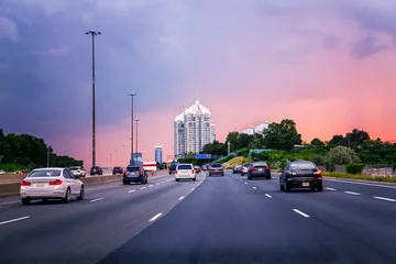 Foto auf Acrylglas Night traffic. Cars on highway road at sunset evening in typical busy american city. Beautiful amazing night urban view with red, yellow and blue sky clouds. Sundown in downtown. © anoushkatoronto