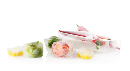 Fresh vegetables frozen in ice cubes on white background