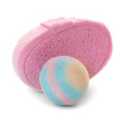 Pink sponge and bath bomb on white background