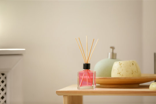 Aromatic reed air freshener and toiletries on table indoors
