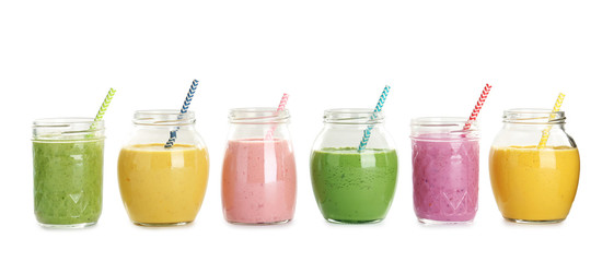Jars with fresh tasty smoothies on white background