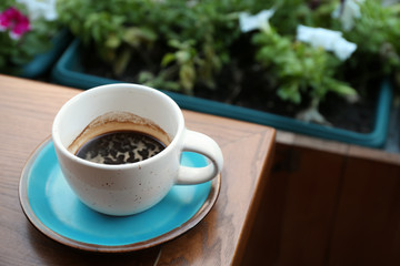 Cup of fresh aromatic coffee on wooden table