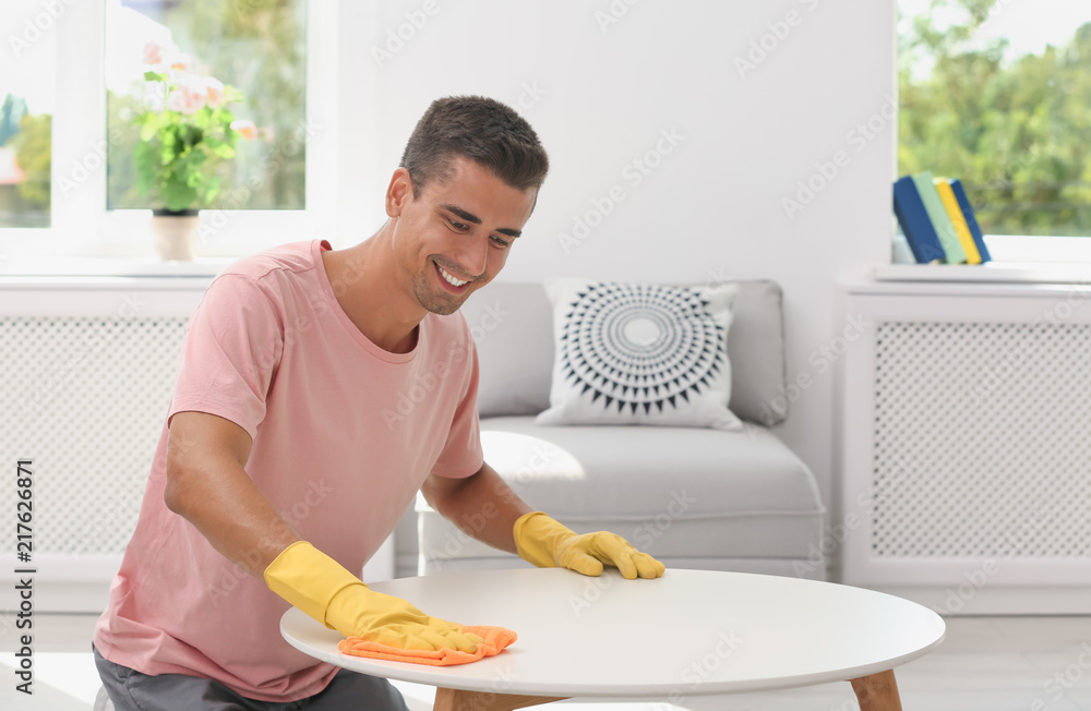 Canvas Prints Man cleaning table with rag in living room