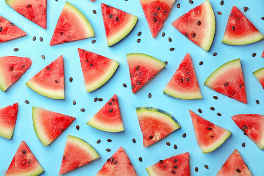Flat lay composition with slices and seeds of watermelon on color background