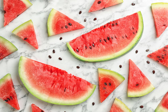 Flat lay composition with slices and seeds of watermelon on marble background