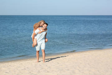 Happy young couple at beach on sunny day