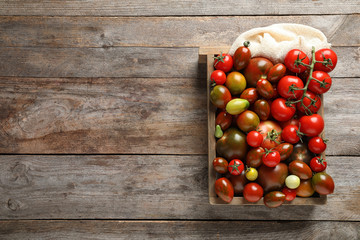 Crate with tasty juicy tomatoes and space for text on wooden background, top view