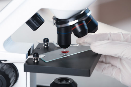 Analyst doing laboratory test with microscope, closeup. Chemical analysis