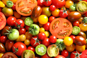 Different sorts of tomatoes as background, closeup