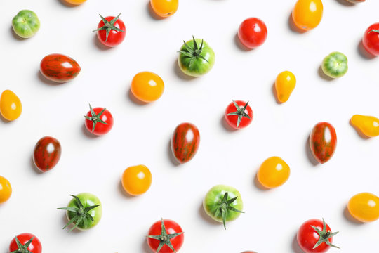 Flat lay composition with different tasty tomatoes on white background