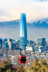 Santiago, Chili - 14 juli 2018: Uitzicht op het Sky Costanera Center en de rode kabelbaan, met moderne kantoorgebouwen en de Andes Cordillera op Cerro San Cristobal.