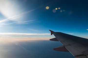 The plane is flying through the sunset sky