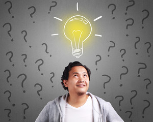 Young Man Having An Idea With Light Bulb Above His Head