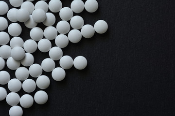 White pills on a black background 


