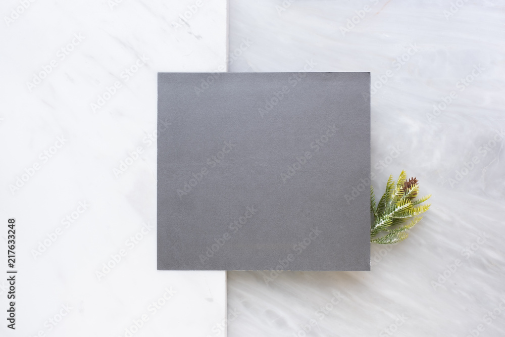 Poster Top view of blank grey card with pine leaf on two layer step of marble table top.Mock up template for display of design .luxury business items.