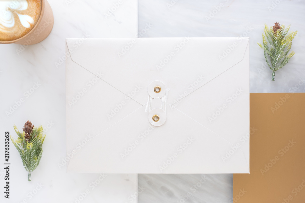 Poster Top view of blank white envelop overlap on gold card with hot coffee cup and pine leaf on two layer step of marble table top.Mock up template for display of design .luxury business items.