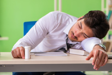 Sick and unhappy businessman sitting in the office 