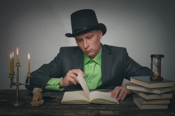 Man in bowler hat and suit is sitting by table. Writer, author, detective or spy agent concept.
