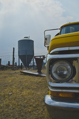 Fototapeta premium The headlight of the old truck on the old rusty farm under the smoke filled sky. 