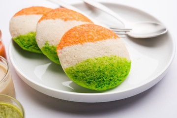 Tiranga Idly or Idli made using Indian National Flag colours like saffron, white and green. Served with colourful chutney. Concept for Happy Independence day greeting card