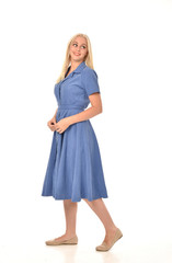 full length portrait of blonde girl wearing blue dress, standing pose. isolated on white  studio background.