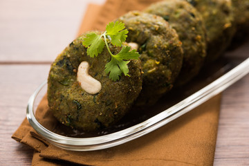 Hara bhara Kabab or Kebab is Indian vegetarian snack recipe served with green mint chutney over moody background. selective focus