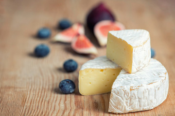 camembert cheese with figs and blueberries on on dark background