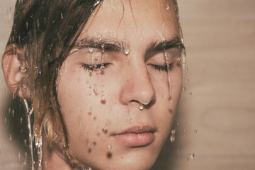 Sexy guy washes in the shower. 