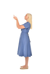 Fototapeta premium full length portrait of blonde girl wearing blue dress, standing pose. isolated on white studio background.