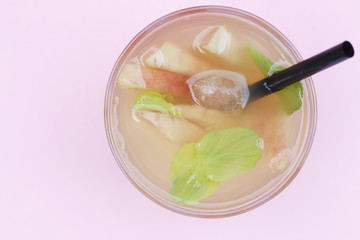 Cocktail from pieces of peach in a transparent glass glass, summer background. Copy space top view