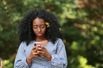 Sad black female with smartphone