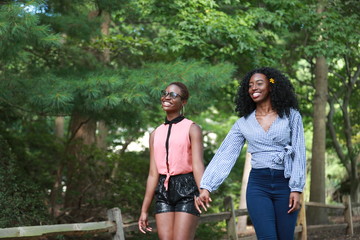 Black women holding hands and walking