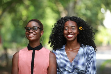 Smiling black friends standing in park