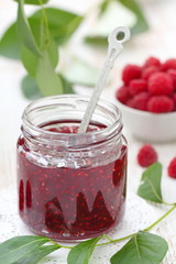 Raspberry jam in a jur and fresh berries on the table